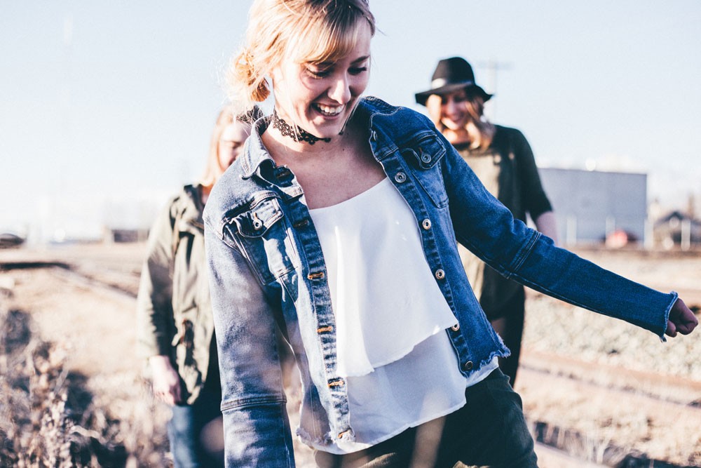 grupo de amigas sonriendo y paseando por un campo 